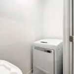 Laundry area with modern top-load washer