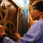 Teen figuring out a gear puzzle during an immersive escape room adventure at Escapology.